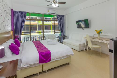 a bedroom with a bed and a desk and a couch at Kontiki Guesthouse in Jomtien Beach