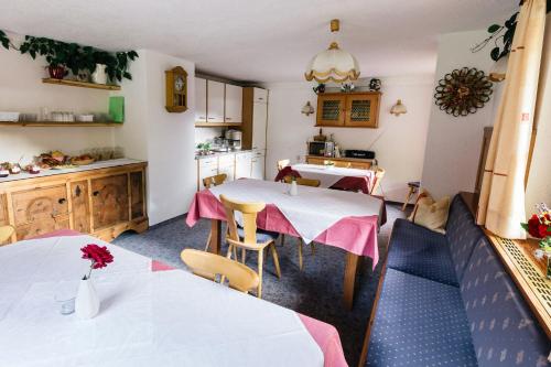 a kitchen and dining room with two tables and chairs at Gaestehaus Berger in Sankt Jakob in Defereggen