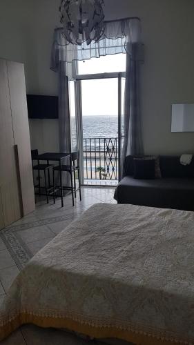 sypialnia z łóżkiem i widokiem na ocean w obiekcie B&B del Mare w mieście Pozzuoli