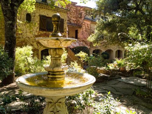a fountain in a garden in front of a house at Domaine du Bois d'Amont in Cabris