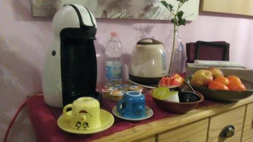 a counter with affeepot and a jug of water and fruit at Charme&Chic in Trieste