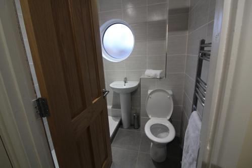 a small bathroom with a toilet and a sink at Maryville Apartment by Townlets in Belfast