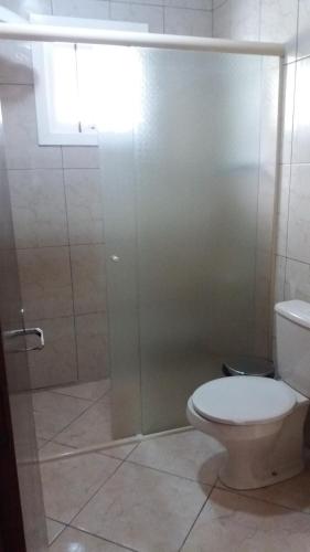a bathroom with a toilet and a glass shower at Casa da Vó Nelsi in Gramado