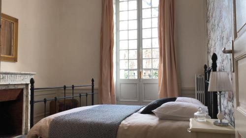 a bedroom with a bed and a large window at Boulevard Jules Ferry in Brive-la-Gaillarde