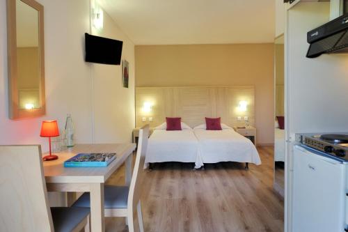 SerrieraにあるHotel Stella Marinaのベッドルーム1室(ベッド1台、テーブル、デスク付)
