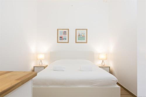 - une chambre avec un lit blanc et deux lampes dans l'établissement Augustins -Petit cocon calme et lumineux avec parking, à Bordeaux