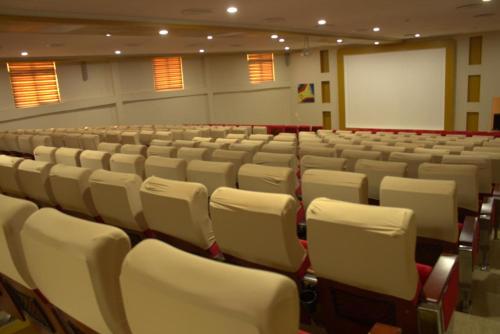 an empty lecture hall with white chairs and a whiteboard at Eusbett Hotel in Sunyani