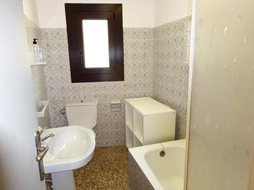 a bathroom with a sink and a toilet and a window at Apartamentos Arinsal 3000 in Arinsal