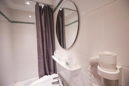 La salle de bains est pourvue d'un miroir, de toilettes et d'un lavabo. dans l'établissement Hotel Der Tannenbaum, à Munich