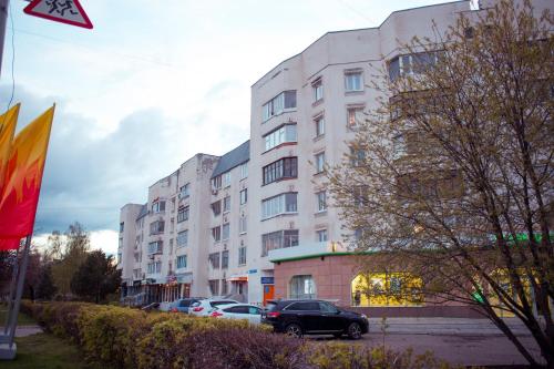 a large white building with cars parked in front of it at Apartment Lenina in Vladimir