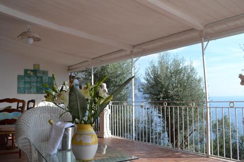a vase of flowers on a table on a balcony at Villa Petit Ludovica in Ravello
