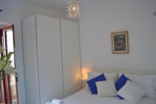 a bedroom with a bed with blue and white pillows at Villa Petit Ludovica in Ravello