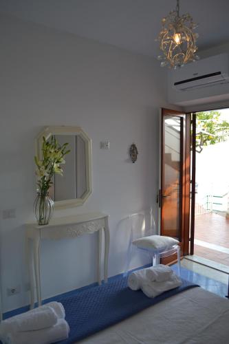 a bedroom with a bed and a table and a mirror at Villa Petit Ludovica in Ravello