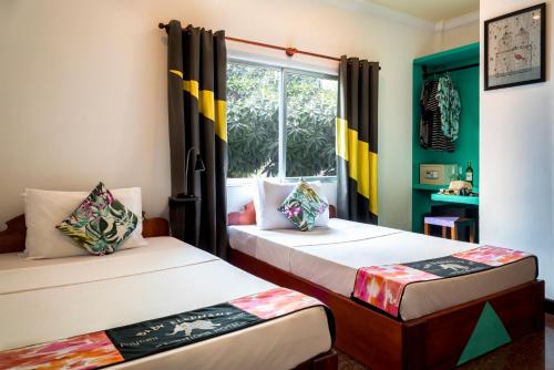 Duas camas num quarto com uma janela em Baby Elephant Boutique Hotel em Siem Reap