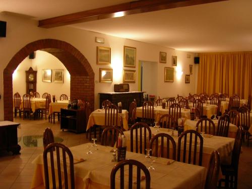 a dining room with tables and chairs with white table cloth at Hotel La Pergola in Moniga