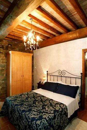 a bedroom with a bed and a chandelier at Villa Ceppeto in Monte San Savino