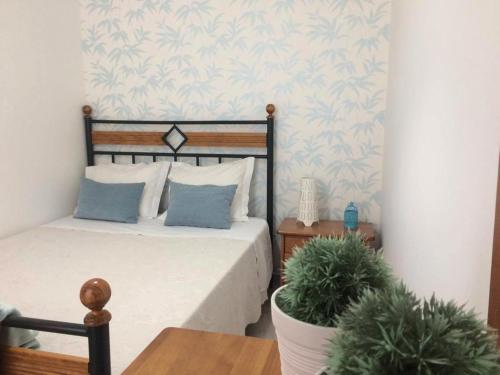 um quarto com uma cama e um vaso de plantas em Casa BeijoMar em Nazaré