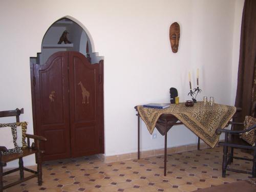 a room with a table and a wooden door at Villa Daba in Ghazoua