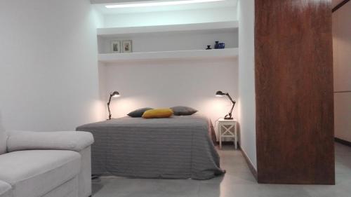 a bedroom with a bed with two lamps and a couch at Shearwaters - Sounds of the sea in Funchal