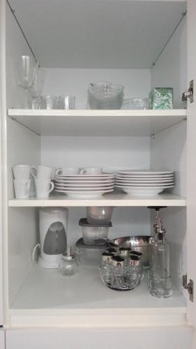 a white shelf with dishes and plates on it at Shearwaters - Sounds of the sea in Funchal