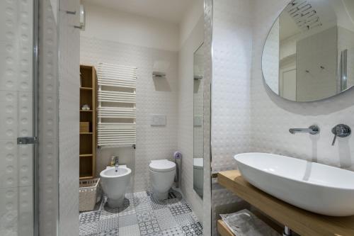 a bathroom with a sink and a toilet and a mirror at Moscova Luxury B&B in Milan