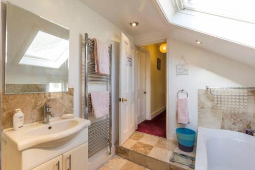 a bathroom with a sink and a bath tub at Endearing Edwardian House in Quaint Deal, Kent in Deal