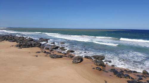 a group of rocks on a beach near the ocean at Stroke-One-Inn in Umkomaas