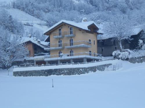 a house with snow on the ground in front of it at Affittacamere Les Noyers in Verrayes