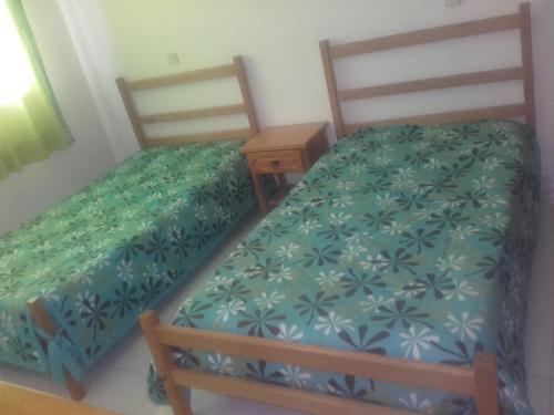 two twin beds in a room with a night stand at Albufeira INN - Casa do Pacífico - Elimar 3 T1 in Albufeira