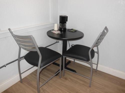 a table with two chairs and a coffee maker on it at Budget Inn - Saint Augustine in Saint Augustine