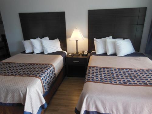 a hotel room with two beds and a lamp at Budget Inn - Saint Augustine in Saint Augustine