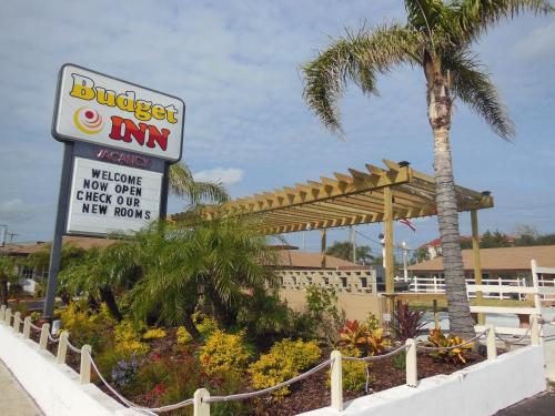 a sign for a buffet inn next to a palm tree at Budget Inn - Saint Augustine in Saint Augustine