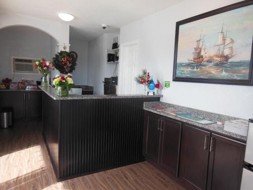 a kitchen with a large painting of a ship on the wall at Budget Inn - Saint Augustine in Saint Augustine