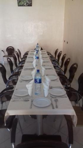 a long table with plates and bottles of water on it at Maison d'hôtes afoulki tafraout in Tafraoute
