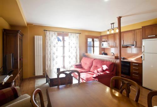 sala de estar con sofá rojo y mesa en Apartamentos El Rincón de Benás, en Benasque