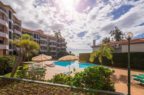 a swimming pool with umbrellas in a resort at Varandas do Funchal I by An Island Apart in Funchal