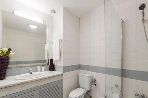 a bathroom with a toilet and a sink and a mirror at Varandas do Funchal I by An Island Apart in Funchal