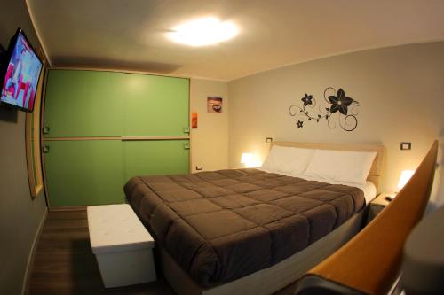 ナポリにあるL'oro di Napoliのベッドルーム1室(緑のドア、テレビ付)