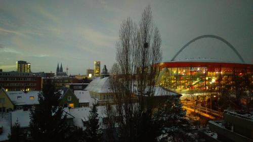 a view of a city at night with a building at Köln Deutz/Messe, Lanxess Arena in Cologne