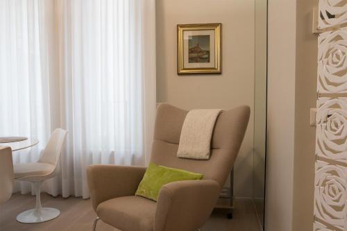 a living room with a chair with a green pillow at Milano Porta Venezia Suite Centro in Milan