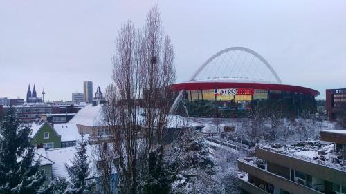 a large building with a dome in a city at Köln Deutz/Messe, Lanxess Arena in Cologne