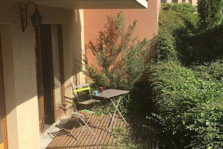 a picnic table sitting on the side of a house at Appartement aux Airelles in Embrun