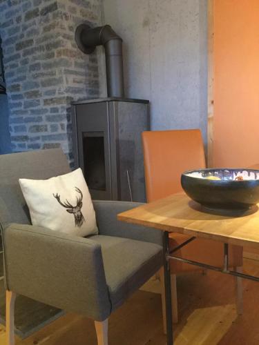 a living room with a chair and a table with a bowl at CaLegna Ferienchalet in Bad Kohlgrub
