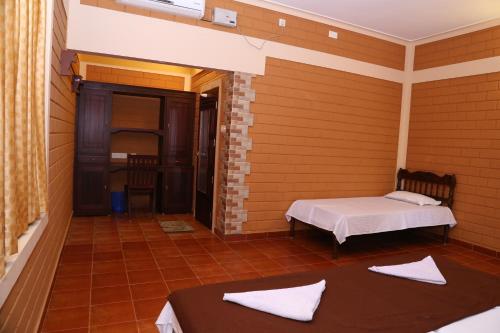 a room with two beds and a door to a room at Dazzle Dew in Alleppey