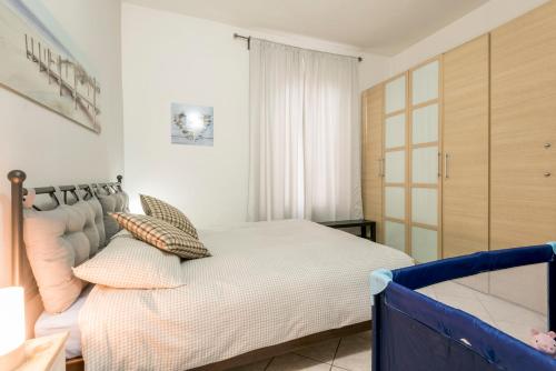a bedroom with a bed with white sheets and pillows at Casa Sofia -Airport free shuttle-H24 in Bergamo