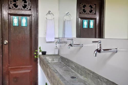 a bathroom with a sink and a mirror and a door at Bona Vida Hostel in Ríohacha