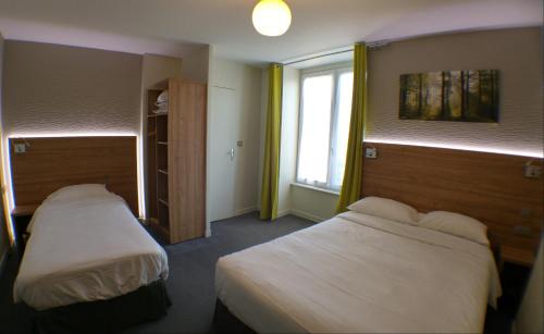 a hotel room with two beds and a window at Hôtel Le Verger in Saint Laurent Nouan
