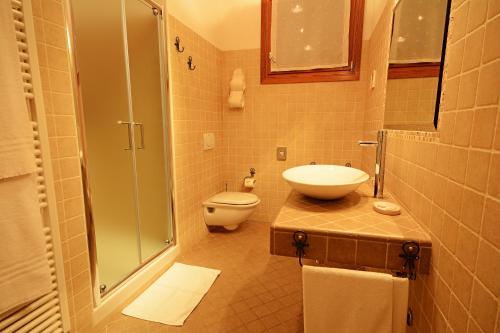 a bathroom with a toilet and a sink and a shower at Locanda Gli Ulivi in Monteveglio