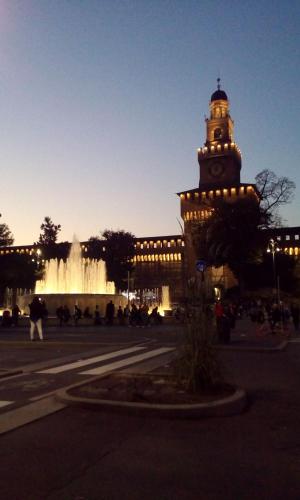 a building with a clock tower in front of a fountain at Hotel Tirreno in Milan