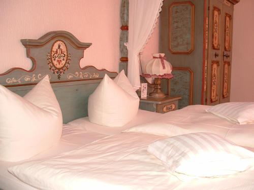 a bed with white sheets and pillows in a bedroom at Hotel Reinhold in Gummersbach